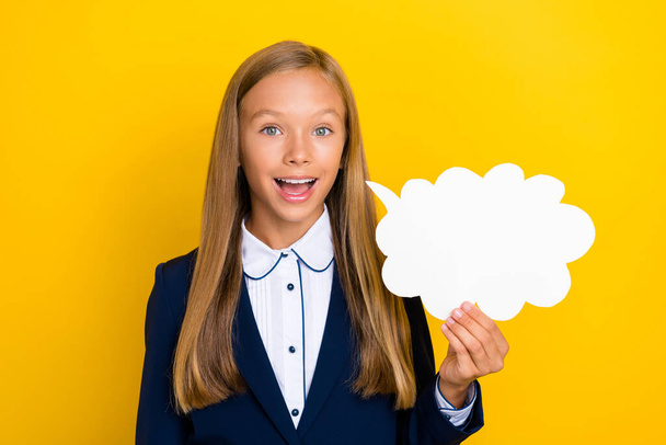 Photo of cheerful positive girl hand hold white card give answer report lesson homework empty space isolated on yellow color background. - Photo, Image