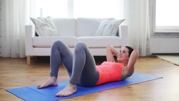 улыбающаяся девушка делает упражнения на коврике дома
 - Кадры, видео