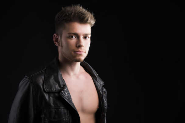 Attractive young man with leather jacket on naked torso - Photo, image