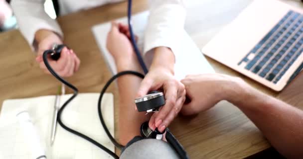 医者は診療所で患者の血圧をチェックします。動脈性高血圧と圧力サージの原因と治療 - 映像、動画