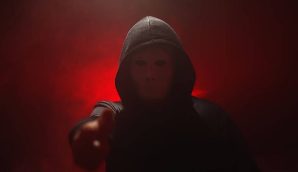 Anónimo en máscara hace un anuncio. - Foto, Imagen