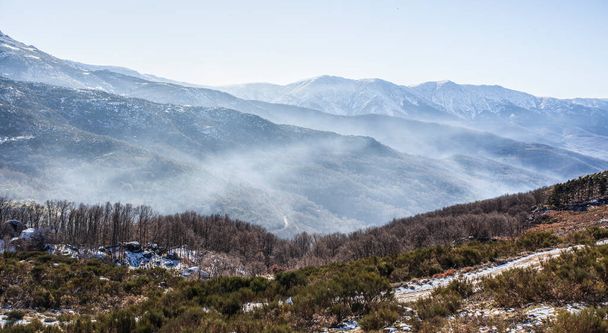 Nebelschwaden zwischen schneebedeckten Gipfeln der Sierra de Gredos. La Garganta, Ambroz-Tal, Extremadura, Caceres, Spanien - Foto, Bild