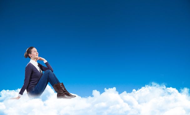 Liikenainen istuu pilvien päällä
 - Valokuva, kuva