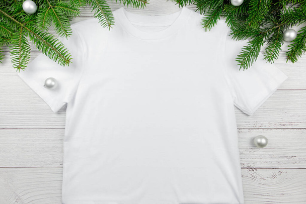 Fehér nők pamut póló mockup karácsonyfa ágak és dekoráció. Tervezés t ing sablon, nyomtatás bemutató lapos feküdt mock up.  - Fotó, kép