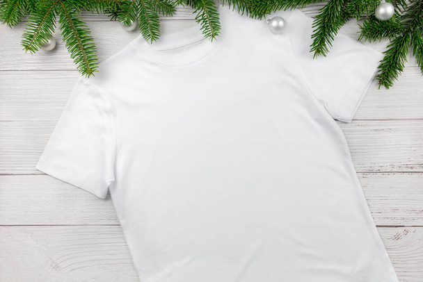 Fehér nők pamut póló mockup karácsonyfa ágak és dekoráció. Tervezés t ing sablon, nyomtatás bemutató lapos feküdt mock up.  - Fotó, kép