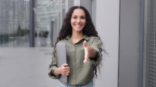 Caucasian 30s friendly businesswoman freelancer worker lady woman with laptop standing outdoors city holding hand in front welcome gesture hi sign ready to meeting handshaking nice to meet you symbol - Footage, Video