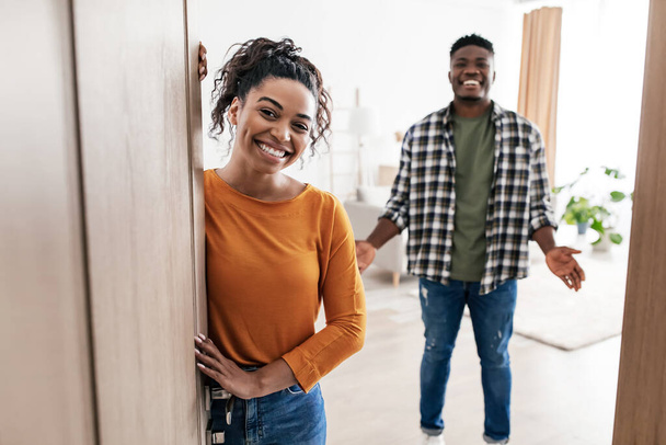 Evimize hoş geldiniz. Afro-Amerikan eşleriyle tanışma ve evdeki açık kapılar önünde duran kameraya gülümseme. Aile Konutları. Seçici Odaklanma - Fotoğraf, Görsel