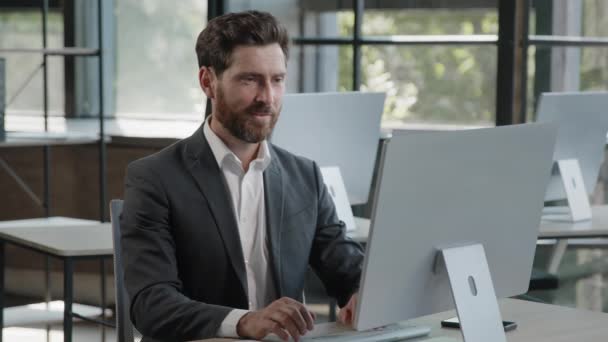 Caucasian bearded man boss leader worker manager businessman finish online project startup work day off with computer in office relaxes smiling satisfied leans back on chair holding hands behind head - Footage, Video