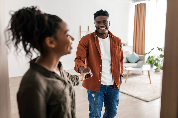 Mutlu Siyah Eş Kocanın Elini Tutuyor Yeni Evde Açık Kapı 'da Duruyor. Emlak Teklifi ve Mülk Sahipliği Konsepti. Seçici Erkek Odaklanma - Fotoğraf, Görsel