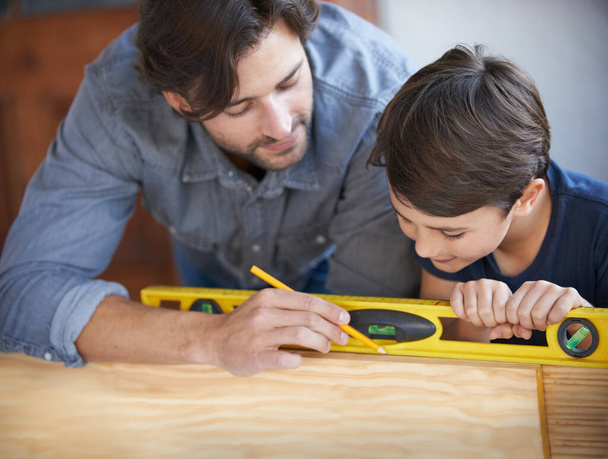 Zeigt ihm, wie man bastelt. Vater und Sohn machen gemeinsam Holzarbeiten - Foto, Bild