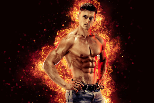 Bodybuilder posing on the fire flames background. High quality photo - Foto, Imagem