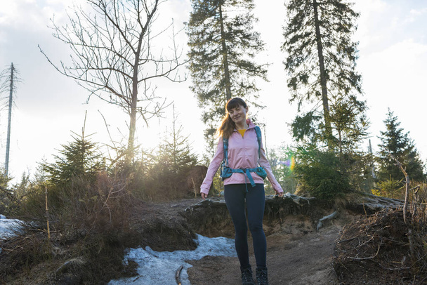 若い幸せな女性の春の雪の中を歩くと、単独でハイキング。自由と積極的なライフスタイルの概念. - 写真・画像
