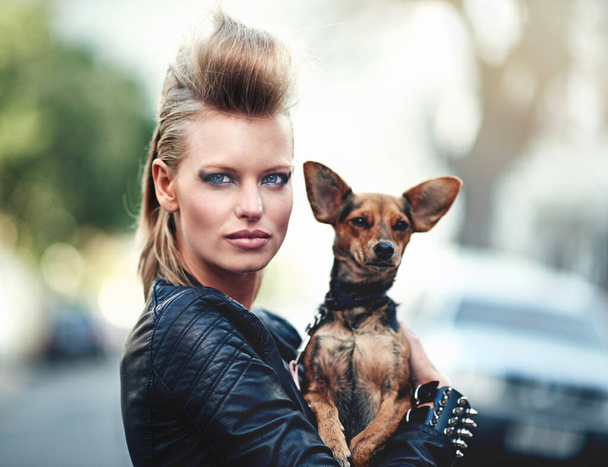 Étaient si rock n roll. Portrait recadré d'une jeune femme agitée tenant son petit chien à l'extérieur - Photo, image