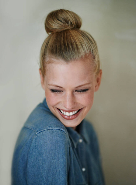 Smiling shyly. A beautiful young woman in casualwear - studio shot - Fotoğraf, Görsel