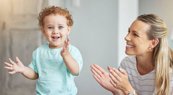 Ευτυχισμένο χειροκρότημα, υποστήριξη μητέρας και παιδί με ενέργεια στο σαλόνι, χαμόγελο για γιορτή και οικογενειακή αγάπη στο σαλόνι του σπιτιού. Πορτρέτο του μωρού με χαρά και χειροκρότημα κατά την ανάπτυξη του παιδιού με τη μαμά. - Φωτογραφία, εικόνα