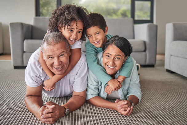 Grandparents, children or bonding in fun play game on house or family home living room floor. Portrait, smile or happy senior man and mature woman babysitting grandchildren or kids together in lounge. - Photo, Image
