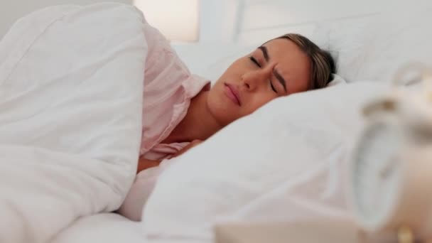 Sleeping woman in bed annoyed, snooze alarm clock, continue sleep on pillow after stop ringing noise in her home. Girl awake to sound from analog watch on table in bedroom, take nap under blanket. - Metraje, vídeo