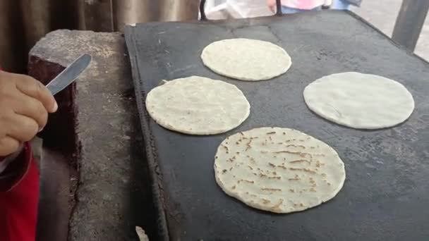 Κοντινό πλάνο στα χέρια μιας Λατίνας που μαγειρεύει τορτίγιες καλαμποκιού σε μια μεταλλική σχάρα στη Μανάγκουα της Νικαράγουα - Πλάνα, βίντεο