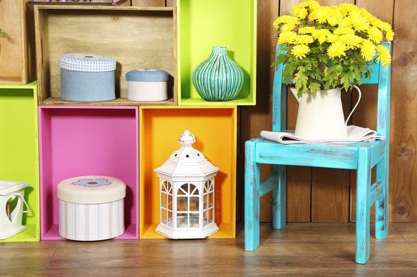 Hermosos estantes coloridos con diferentes objetos relacionados con el hogar en fondo de pared de madera
 - Foto, imagen