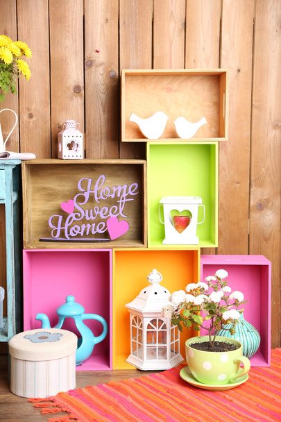 Beautiful colorful shelves with different home related objects on wooden wall background - Φωτογραφία, εικόνα