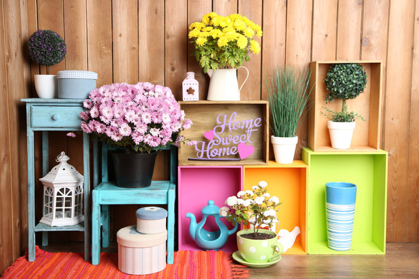 Beautiful colorful shelves with different home related objects on wooden wall background - Valokuva, kuva