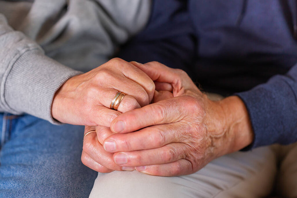 Senior married couple holding hands together. Family, help, elderly care and support concept - Fotó, kép