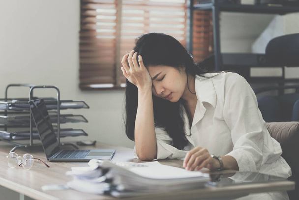Gestresste asiatische Geschäftsfrau mit Papierkram im Büro. Burnout-Syndrom oder Terminplanung. - Foto, Bild