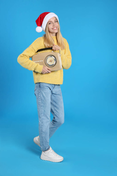 Happy woman with vintage radio on blue background. Christmas music - Foto, Imagem