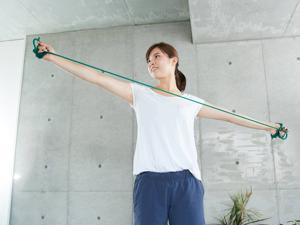 Vrouw doet een tube workout - Foto, afbeelding