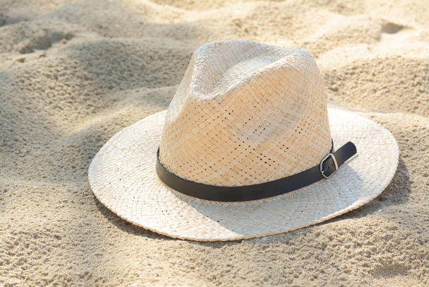 Stylish straw hat on sand outdoors. Beach accessory - Foto, afbeelding