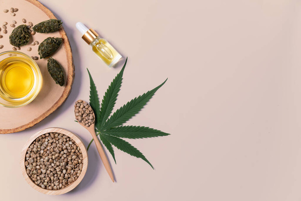 Bottle of CBD oil, THC tincture, cannabis leave, hemp seed on the wooden bowl arranged together on the white background. Hemp plant cannabidiol distillation into liquid for medical use. - Photo, Image