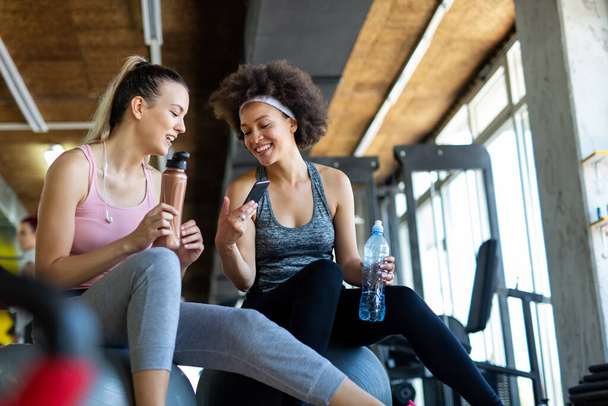 Beautiful young women working out in gym together to stay healthy. Sport, people, friend concept. - Foto, Bild