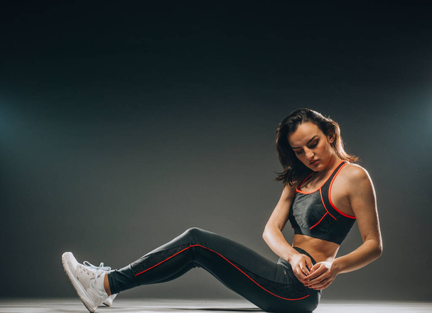 attrayant jeune Caucasien américain sport fitness femme en sportswear posant travailler isolé sur fond sombre en studio - Photo, image