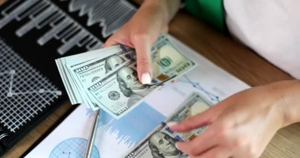 Naisten kädet laskenta dollarin valuutan pöydälle kaavioita lähikuva 4k elokuva hidastettuna. Rikollisuus ja lahjonta liiketoiminnassa - Materiaali, video