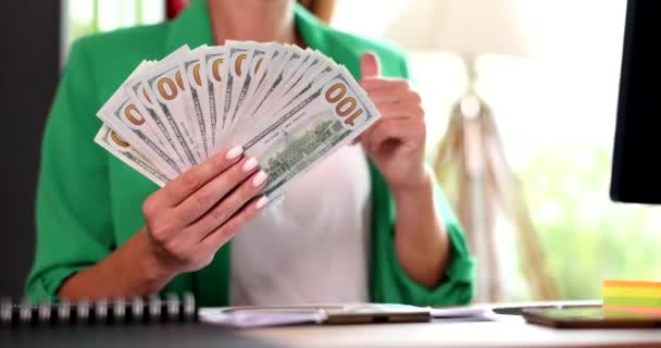 Podnikatelka drží mnoho dolarových bankovek a ukazuje palec nahoru detailní 4k film zpomalení. Úspěšný výnosný obchodní koncept - Záběry, video