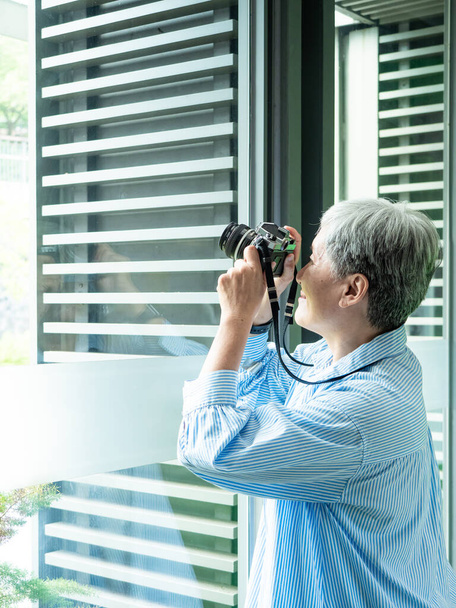 Portrét šťastného seniora starší asijské ženy 60s fotografování s fotoaparátem pro koncept cestování. - Fotografie, Obrázek
