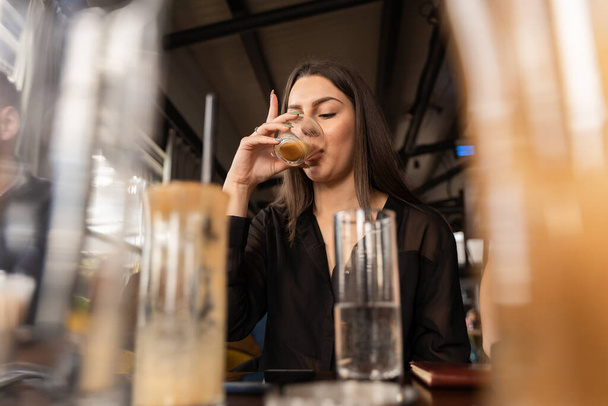 Aantrekkelijke en verbazingwekkende jonge zakenvrouw drinkt haar koffie - Foto, afbeelding