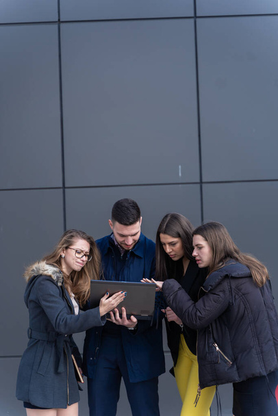 Groupe de jeunes gens d'affaires regardent le PC portable et de discuter - Photo, image