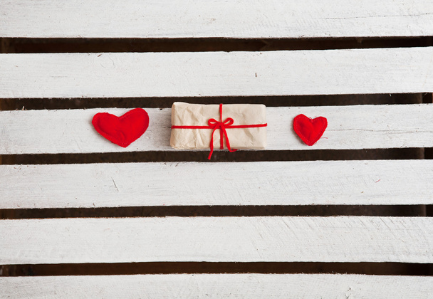 zwei rote Herzen und Geschenk auf weißem Holzhintergrund - Foto, Bild