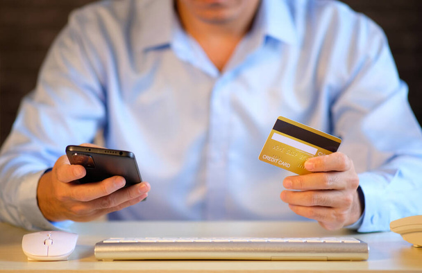 człowiek posiadający kartę kredytową i korzystający z telefonu, koncepcja płatności online - Zdjęcie, obraz