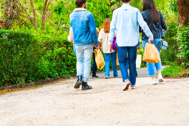 jóvenes caminan con llevar en la mano - bolsas de papel con comida en la mano - Concepto de entrega. - Foto, Imagen