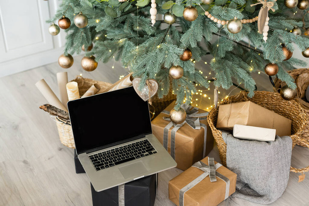 ギフトボックスとクリスマスライトのあるノートパソコンの背景. - 写真・画像