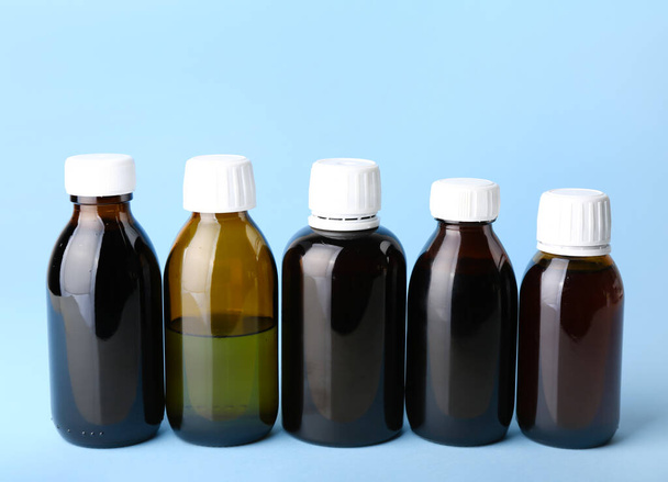Bottles of cough syrup on blue background - Фото, изображение