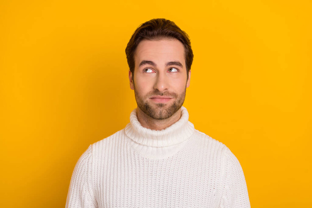 Photo of thoughtful pretty guy dressed white sweater looking empty space isolated yellow color background. - Foto, immagini