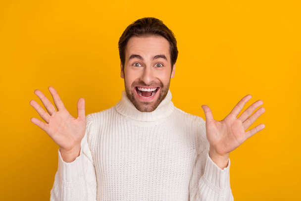 Photo of crazy shocked guy raise hands rejoice exciting promotion news wear white sweater isolated yellow color background. - Фото, зображення