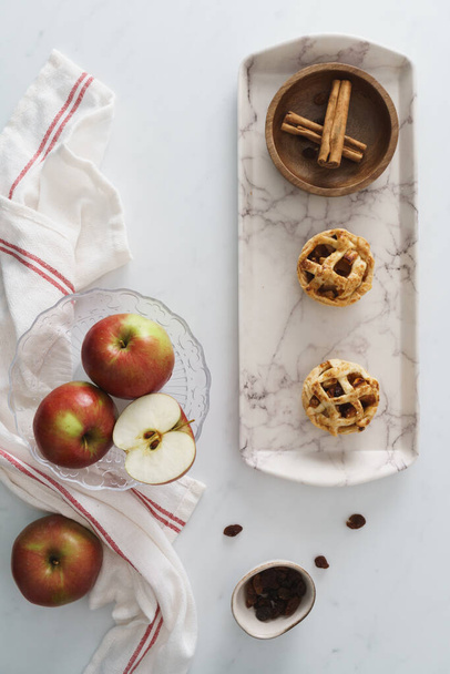 Яблоко и пирожные с корицей на белом фоне. Изображение еды с доступным местом для копирования - Фото, изображение