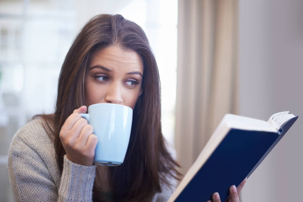 Lesen Sie einen interessanten Artikel. Eine junge Frau liest zu Hause ein Buch - Foto, Bild