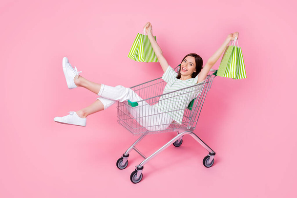 Full length photo of overjoyed lady stylish trendy outfit sit trolley hold eco environment recycled bag isolated on pink color background. - Фото, зображення