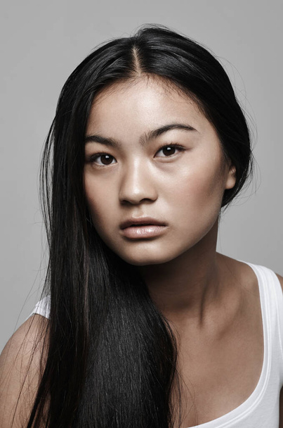 Shes simply gorgeous. Studio shot of a beautiful young woman posing against a gray background - 写真・画像