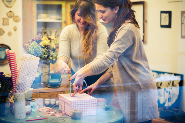 Two women packing gifts - 写真・画像